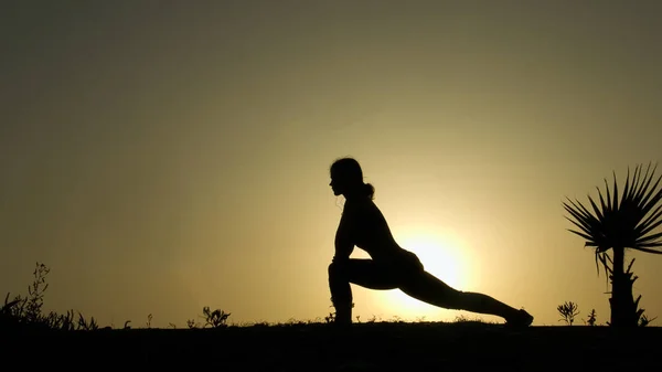 Kvinnliga siluett öva yoga mot solnedgång sky, inre harmoni, lugn — Stockfoto