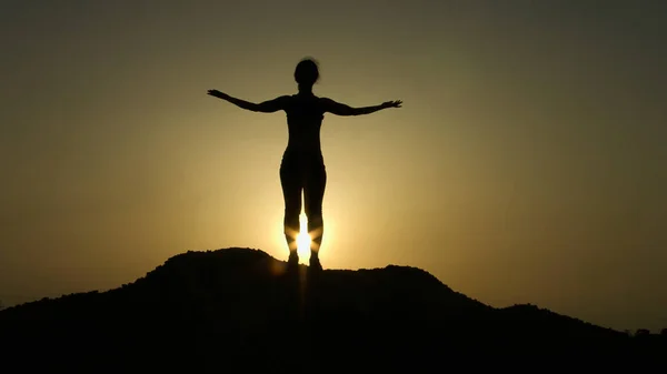 Silhouette in cima alla collina saluto alba con le mani alzate, aspirazione, speranza — Foto Stock