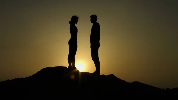 Ζευγάρι στην κορυφή του λόφου κατά την δύση του ηλίου, μοιραία συνάντηση στην άκρη της γης, αγάπη — Φωτογραφία Αρχείου