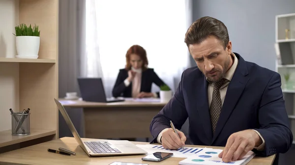 Bedrijf werknemer het controleren van documenten met grafieken, vergelijken van resultaten, data-analyse — Stockfoto