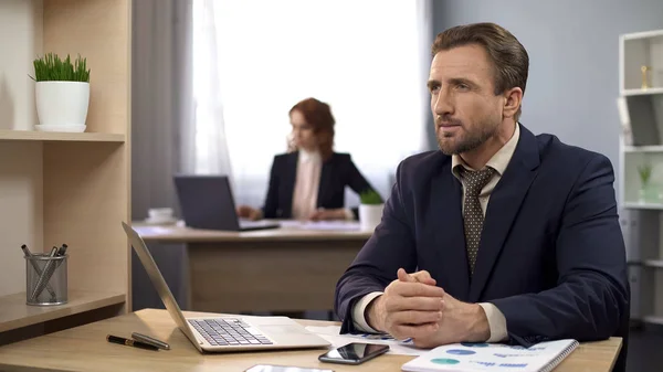 Male in business suit sitting at desk and thinking about income, workplace — Stock Photo, Image