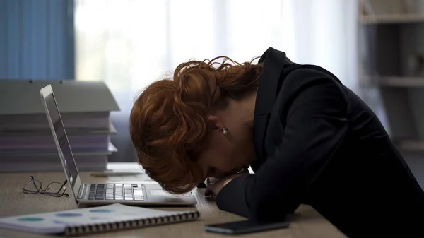 Mulher exausta deitada na mesa do escritório, trabalhando duro no projeto, pressão prazo — Fotografia de Stock
