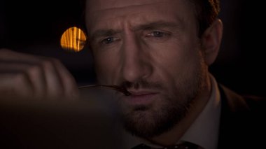 Profesyonel dedektif dizüstü bilgisayarda çalışma gece, gözlük elinde tutan