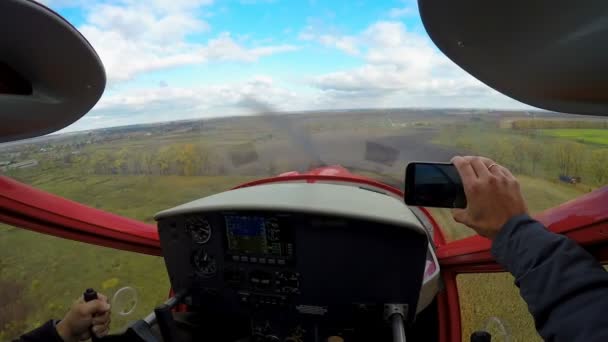 Точка зрения счастливого мужчины съемки спортивного самолета посадки на смартфон, экстрим — стоковое видео