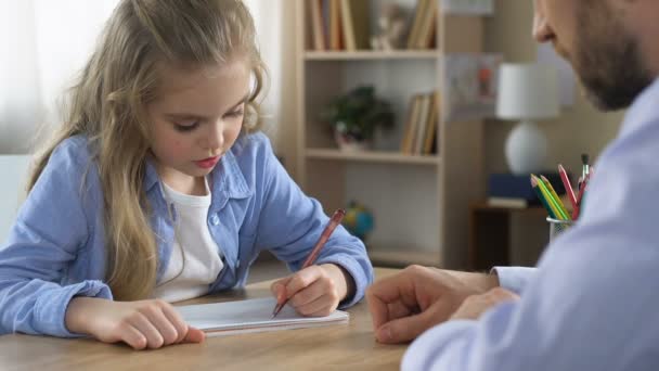 Mädchen schreibt Übungsheft mit Tutorhilfe, zusätzliche Ausbildung, Unterstützung — Stockvideo