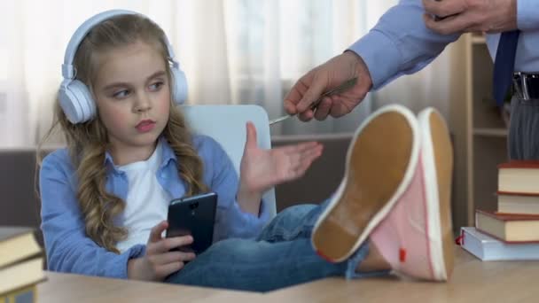 Meisje in hoofdtelefoons nemen vader geld en brengen van de zak, verwend kind, negeren — Stockvideo