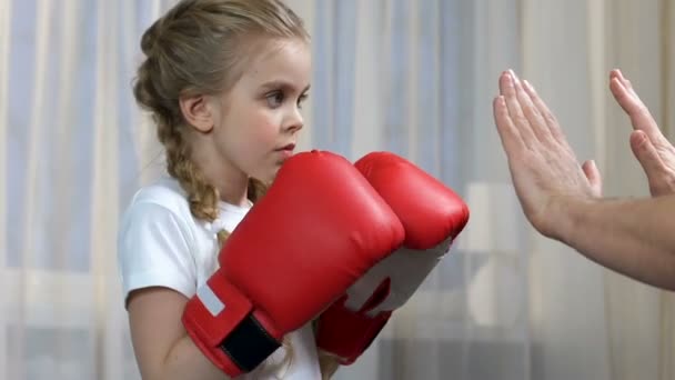 Meisje beoefenen van boksen stoten met vader thuis, sport onderwijs, discipline — Stockvideo