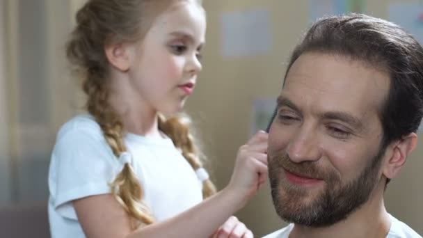 Fille attentionnée peigner les cheveux du père et embrasser la joue, l'amour de la famille, la parentalité — Video