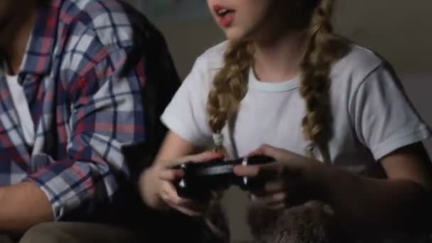 Kleines Mädchen, das Steuerknüppel drückt und zu Hause Videospiel mit seinem Vater spielt — Stockvideo