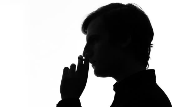 Задумчивый молодой человек курит сигарету, грустное настроение и одиночество, депрессия — стоковое видео