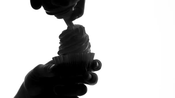 Man pouring whipped cream on cupcake, risk of diabetes, sugar level control — Stock Video