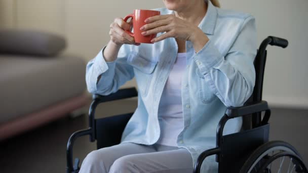 Seniorin im Rollstuhl trinkt Tee, Rentnerin entspannt zu Hause, Freizeit — Stockvideo