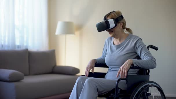 Donna in pensione in sedia a rotelle indossando occhiali vr e godendo di gioco, tecnologia — Video Stock