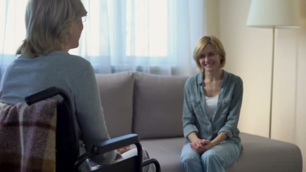 Glada dotter och mor i rullstol prata och skratta, familj stödja — Stockvideo