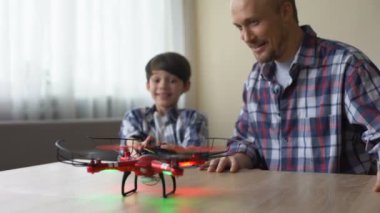 Neşeli çocuk ve babası evde quadcopter, boş zaman, aygıt faaliyet