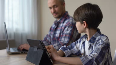 Tablet laptop evde, becerikli alet çalışma baba süre oyun oynayan erkek çocuk