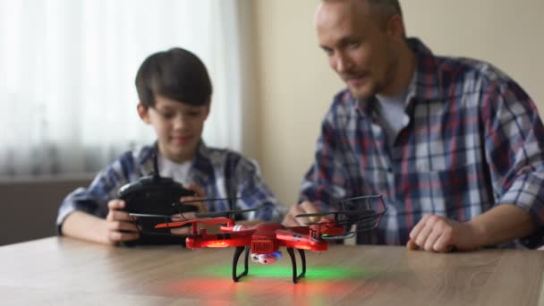 Alegre niño operando dron con control remoto, papá captura quadcopter, diversión — Vídeo de stock