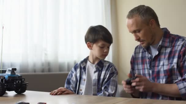 Father and son operating radio-controlled car, leisure activity, birthday gift — Stock Video