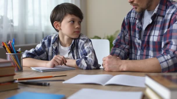 Padre rimproverando figlio, facendolo fare i compiti, ragazzo che inizia a scrivere compito — Video Stock