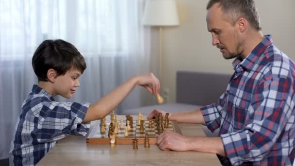 Männliches Kind gewinnt Schach mit dem Vater, kleiner Sohn schüttelt dem Vater die Hand, Hobby — Stockvideo