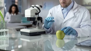 Laboratuvar işçi holding şırınga ile kimyasal sıvı enjeksiyon Apple için