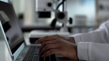 Kadın bilim adamı dizüstü bilgisayar, yazmaya deneysel araştırma laboratuarında çalışan eller