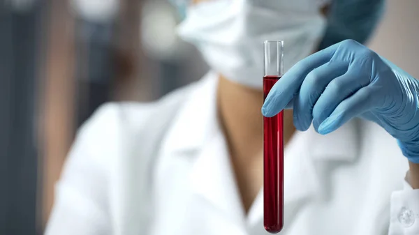Laboratuar asistanı holding tüp kırmızı sıvı, kan analizi araştırma ile