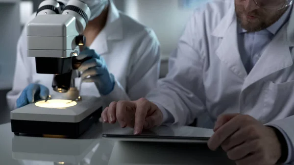 Researcher Studying Sample Microscope Assistant Making Records Tablet — Stock Photo, Image