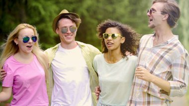 Çok etnik gruptan oluşan bir grup arkadaşıyla birlikte eğlenceli ve rahatlatıcı sahip park, tatil, Toplantı