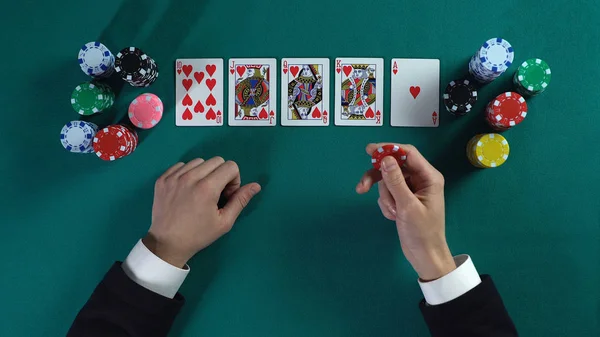 Lucky man has royal flush hand, wins much money in poker game, enjoying success