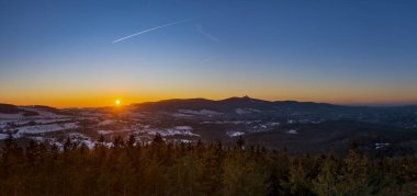 Dağlarda aydınlanmış bulutlarla Liberec 'in dramatik günbatımı gökyüzü. Dağ sırtının koyu siyah silueti ve alttaki Jested verici kulesi..