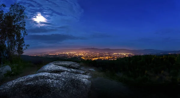 Dramatická liberecká měsíční obloha s osvětlenými mraky v horách. Tmavě černá silueta horského hřebene a ještědské vysílací věže na dně, tmavá, zimní, nihgt. — Stock fotografie