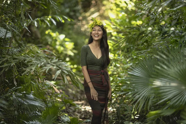 Filipina girl on jungles background. Philippines woman standing up in forest. Girl in jungles. Young girl model with wreath of flowers. Beauty Philippines woman.