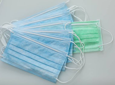 Tıbbi maskeler. Ameliyat maskesi. Farklı renkte tıbbi maskeler. Mavi ve yeşil renkli maskeler. Covid-19. Coronavirus. Kendini soyutlama. Pandemia. Grip, doktor, Asya, Çin, İtalya, ABD, karantina. 