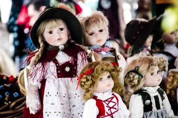 Pequeñas muñecas de niña bonita en venta en los mercados de Salzburgo en Austria. Vestido muy colorido y sombreros y el pelo hacen que las muñecas se vea muy lindo . —  Fotos de Stock