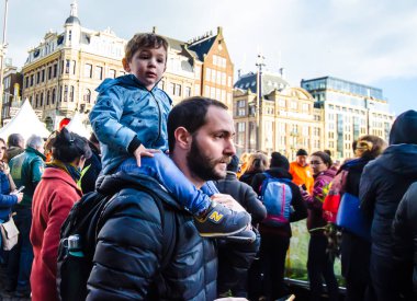 Amsterdam / Hollanda 18 Ocak 2020: Amsterdam Lale Festivali için Amsterdam Barajı meydanında babasının omuzlarında