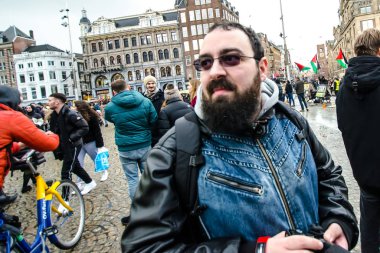 Amsterdam / Hollanda 18 Ocak 2020: Ocak 2020 'deki Lale Festivali sırasında Amsterdam sokaklarında siyah sakallı, güneş gözlüklü ve mavi ceketli bir adam
