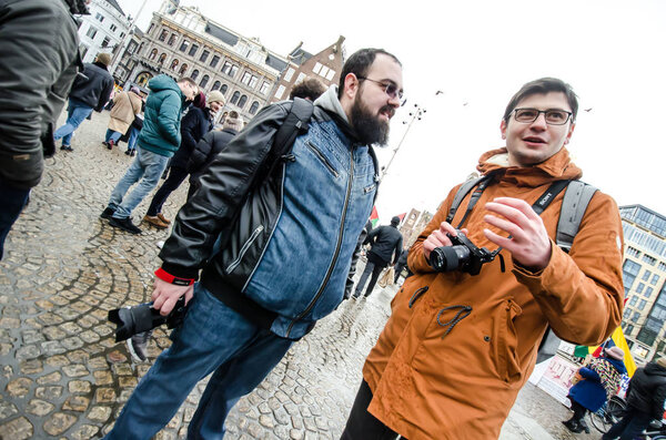 Amsterdam / Netherlands 18th January 2020 : Two men holding cameras in hand discussing in Amsterdam Dam square at Tulip Festival, January 2020