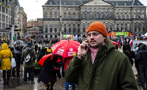 Amsterdam / Hollanda 18 Ocak 2020: Ocak 2020 'de Lale Festivali sırasında Amsterdam Baraj Meydanı' nda cep telefonuyla konuşan bir adam