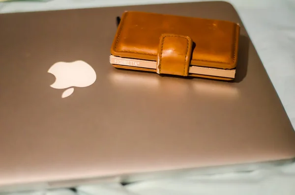 Almere / Hollanda 6 Mart 2020: Macbook profosyonel ve kahverengi cüzdanı bir yatakta