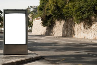 Şehir merkezindeki yol üzerinde palmiye ağaçları olan ilan panosu.
