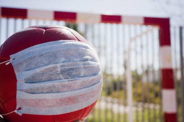 2019-Ncov, futbol topu cerrahi maske takıyor. Koronavirüsü önlemek için cerrahi ekip. Futbol okulu.