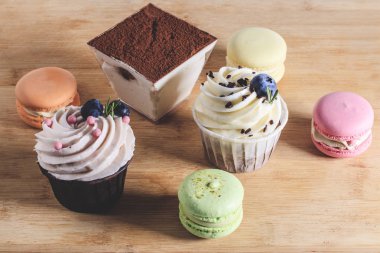 Tahtada yer alan kek, tiramisu, badem kurabiyesi gibi çeşitli tatlılar.