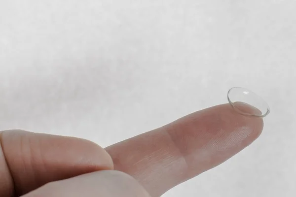 Index finger with a contact lens on it. Close up
