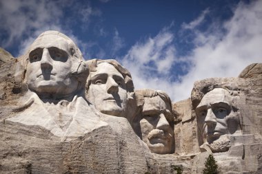 Mount Rushmore National Memorial, four ex Presidents faces sculptured into granite with blue sky and cloud background, Mount Rushmore, South Dakota, USA clipart