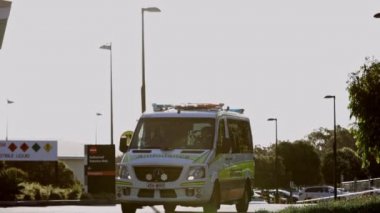 Gold Coast, Avustralya - 17 Mart 2020: Robina hastanesinin önünde karşıdan karşıya geçen ambulans sağlık görevlileri, yolda birbirlerini selamlıyorlar.