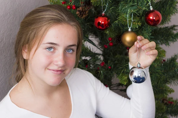 Teenage girl decorating New Year tree — Stock Photo, Image