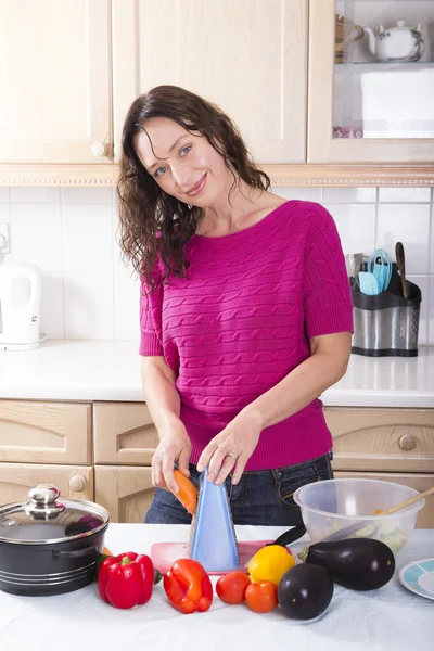 Giovane bruna cucina verdura a casa — Foto Stock