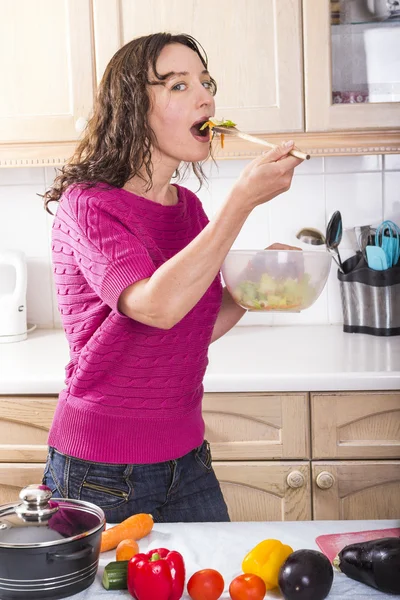 Mulher positiva comendo salada de legumes — Fotografia de Stock
