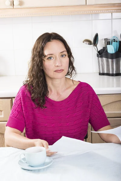 Upset woman with documents in kitchen — Stock Photo, Image